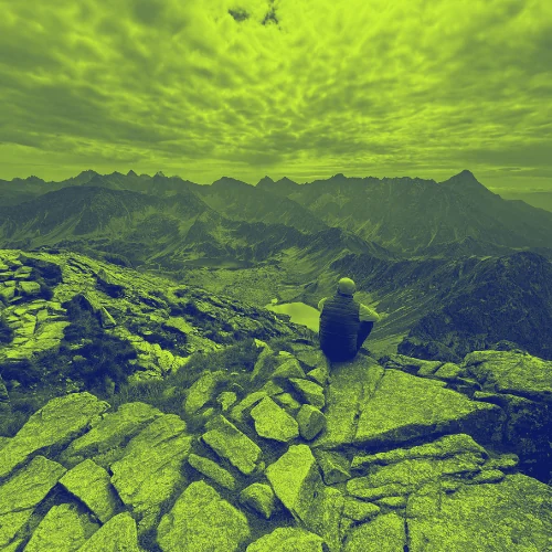 Reisender blickt in der Hohen Tatra vom Gipfel über das Bergpanorama – unterwegs ohne festen Wohnsitz und trotzdem abgesichert