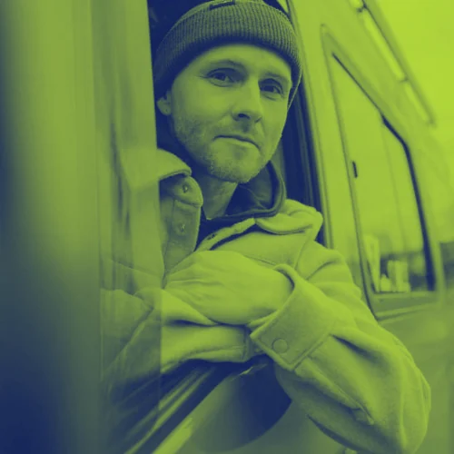 Vanlifer schaut aus dem Fenster seines Campervans – Camper-Lifestyle mit Kfz-Versicherung ohne festen Wohnsitz